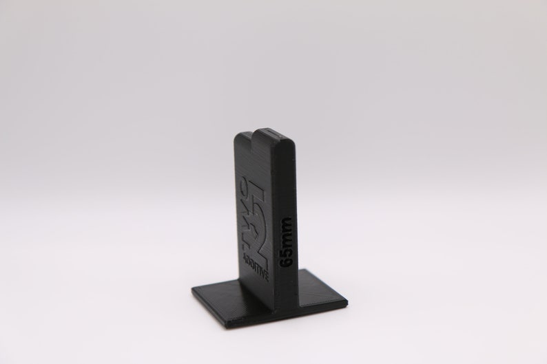 May include: Black plastic tile spacer with the text "65mm" and "ACTIVE" printed on the side.