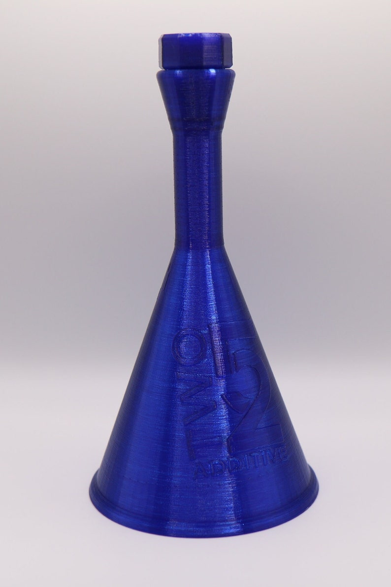 May include: A blue plastic funnel with a small opening at the top and a wide opening at the bottom. The funnel has the words "O.M.G. ADDITIVE" printed on the side.