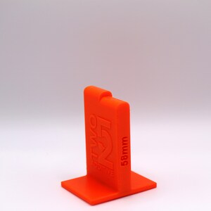 May include: Orange plastic 3D printed stand with the text "Two Positive" and "58mm" printed on the side.