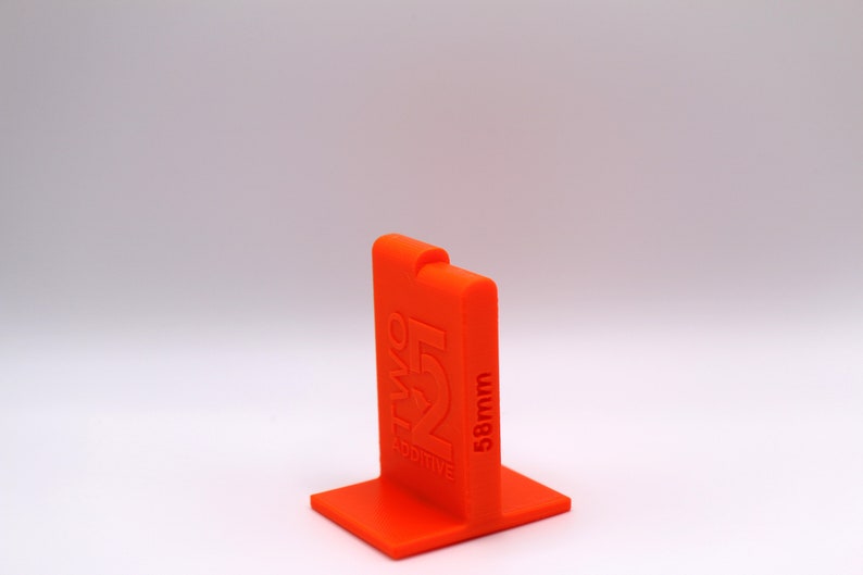 May include: Orange plastic 3D printed stand with the text "Two Positive" and "58mm" printed on the side.