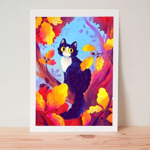 Könnte beinhalten: Ein gerahmter Kunstdruck mit einer schwarz-weißen Katze mit gelben Augen, die in einem Baum sitzt. Das Kunstwerk hat einen farbenfrohen Hintergrund mit Herbstblättern in Gelb-, Orange- und Rottönen. Die Katze ist der Mittelpunkt der Illustration.