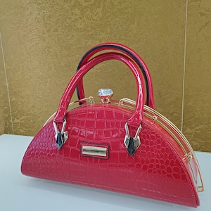 Elegancia chic: bolso de charol negro brillante con detalles dorados