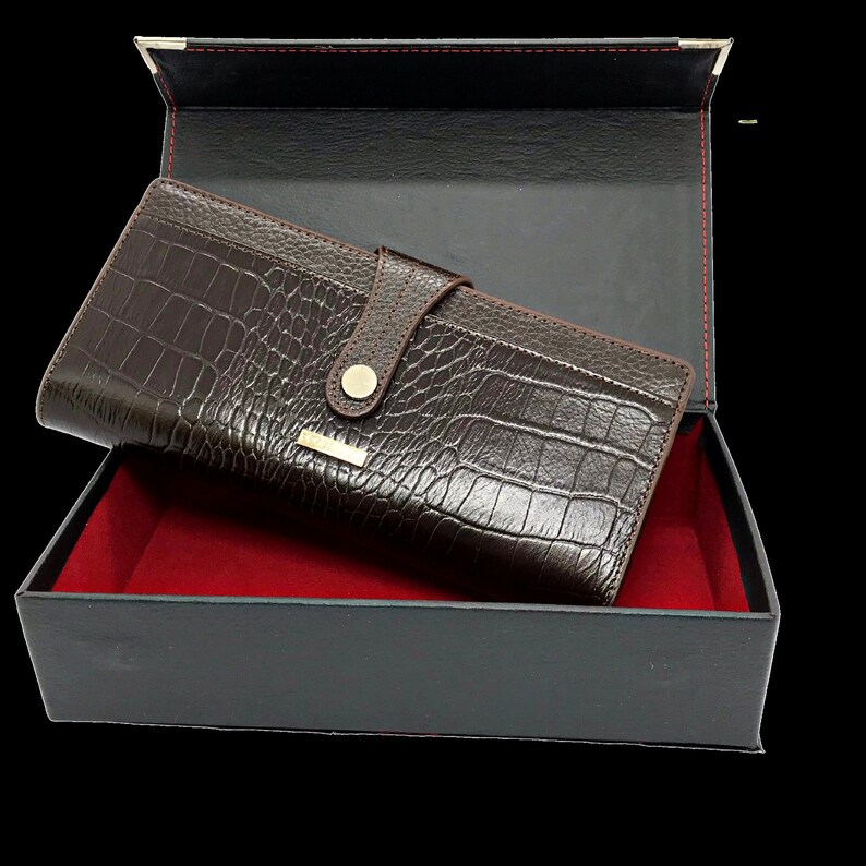 a brown alligator skin wallet in a black box