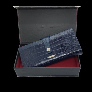 a blue alligator skin wallet in a black box