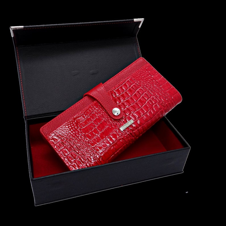 a red alligator skin wallet in a black box