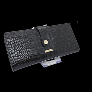 a black alligator skin wallet on a stand