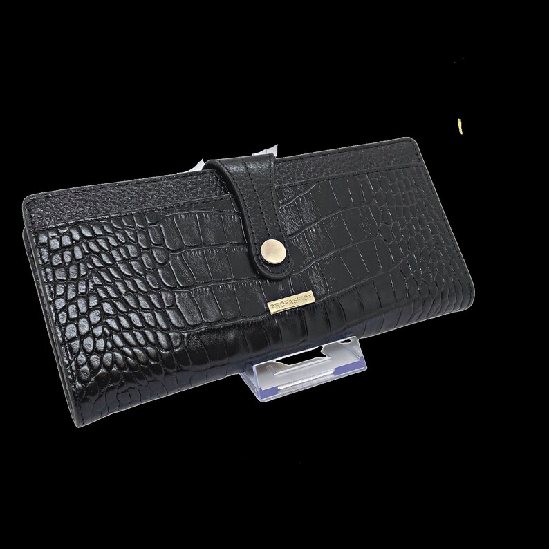 a black alligator skin wallet on a stand