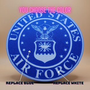 May include: A blue and white round sticker with the United States Air Force logo. The text "YOU CHOOSE THE COLOR" is above the logo. The text "REPLACE BLUE" is below the sticker on the left and "REPLACE WHITE" is below the sticker on the right.