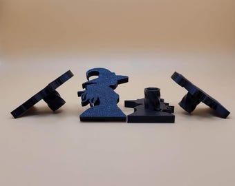 May include: Three black plastic Halloween witch silhouette candle holders. The witch is holding a broom and wearing a hat. The candle holders are designed to hold a small tea light candle.