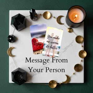 Könnte beinhalten: Ein weißes Marmortablett mit einer brennenden Kerze, schwarzen geometrischen Formen und einer goldenen Mond- und Kreisgirlande. Zwei Karten zeigen ein rotes Herz und ein Paar mit dem Text "You make me wanna do better". Der Text "Message From Your Person" ist ebenfalls sichtbar.