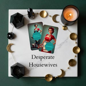 May include: Two rectangular cards labeled Desperate Housewives and Jealousy featuring illustrations of women in vintage aprons, placed on a white marble square with a gold moon phase garland, black geometric candle holders, and a lit candle.