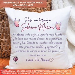 May include: White square cushion with a personalized message in Spanish, featuring butterfly and flower illustrations. The text reads "Para mi hermosa Sobrina Marina" and a loving message. The cushion is designed as a meaningful gift.