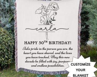 May include: Cream-colored woven blanket with a floral design and the name "carla" in script. The blanket has the text "HAPPY 50TH BIRTHDAY!" and a message. A white starburst graphic says "CUSTOMIZE YOUR BLANKET."