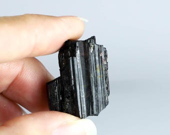 Peut inclure: Un cristal de tourmaline noire avec des stries et une texture brute et naturelle.