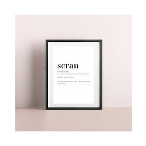 Könnte beinhalten: Ein schwarz-weißer druckbarer Wandkunstdruck mit der Definition des Wortes "scran", das Essen bedeutet. Der Druck ist in einem schwarzen Rahmen gerahmt.
