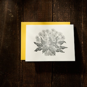 May include: A black and white illustration of a bouquet of flowers with leaves on a white card with a yellow border.
