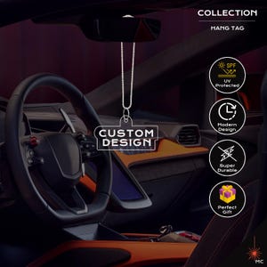 Puede incluir: Una etiqueta colgante transparente con la inscripción "CUSTOM DESIGN" colgando del espejo retrovisor de un coche. La etiqueta está sujeta a una cadena de cuentas plateada. La imagen también muestra iconos de protección UV, diseño moderno, súper duradero y regalo perfecto.