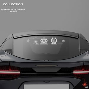 May include: A white rear window/glass holder with a crown, a laser, and a no-smoking symbol. The holder is mounted on the rear window of a black sports car. The text "COLLECTION" and "REAR WINDOW/GLASS HOLDER" are at the top.