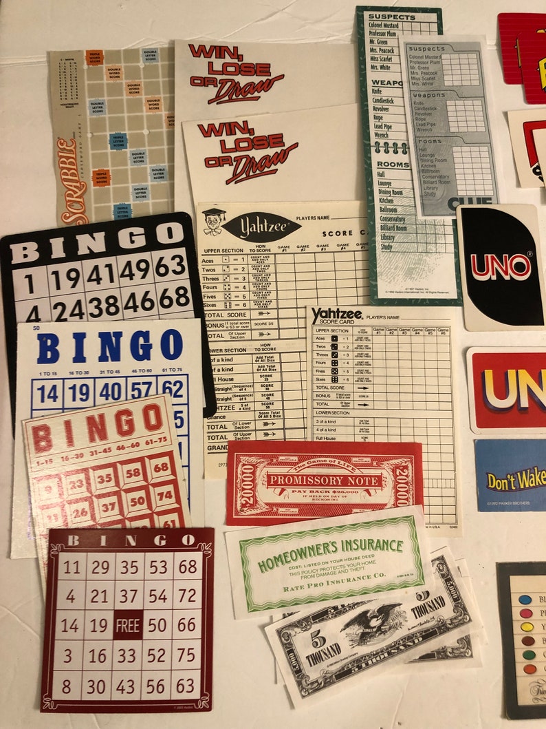 May include: A collection of vintage board game cards and pieces, including Bingo cards, Yahtzee scorecards, Clue suspect and weapon cards, and a Monopoly promissory note. The cards are in various colors, including red, green, blue, and yellow.