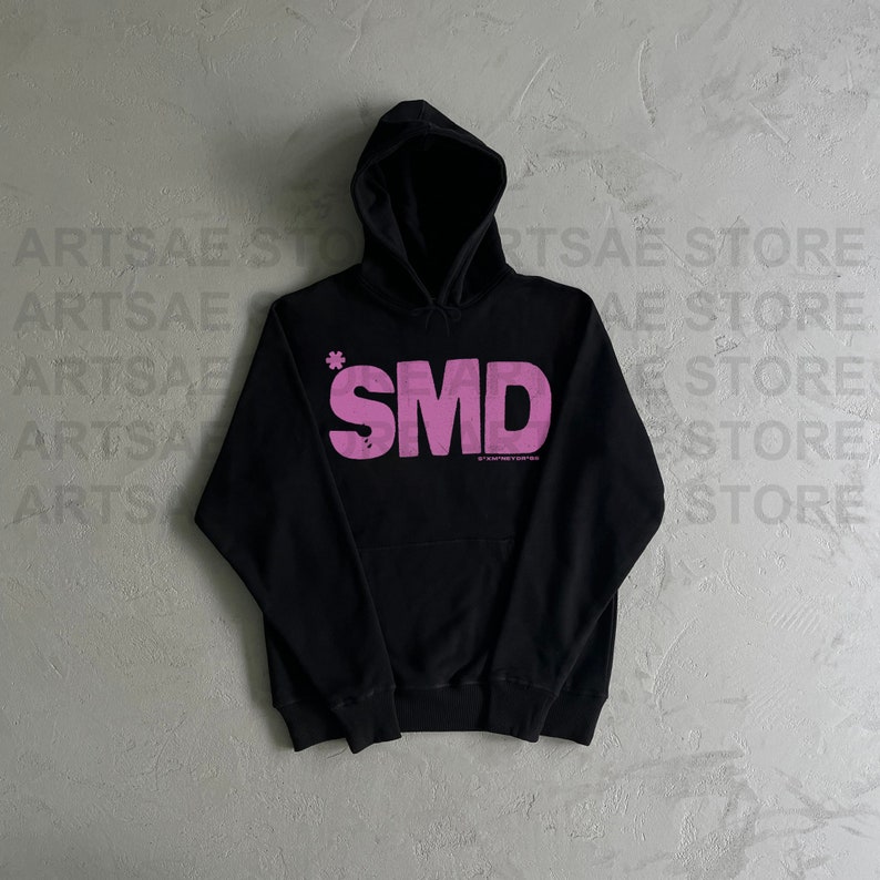 May include: Black hooded sweatshirt with a pink "SMD" logo printed on the front. The logo has a small asterisk above the "S".