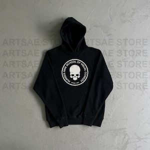 May include: Black hooded sweatshirt with a white graphic of a skull inside a circle with the text "Number Nine School of Visual Comedy Since 1987"