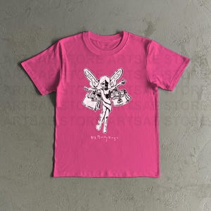 Könnte beinhalten: Ein pinkfarbenes T-Shirt mit einer schwarz-weißen Grafik einer Fee, die zwei Handtaschen hält. Der Text "Six Money Bags" ist unter der Grafik aufgedruckt.