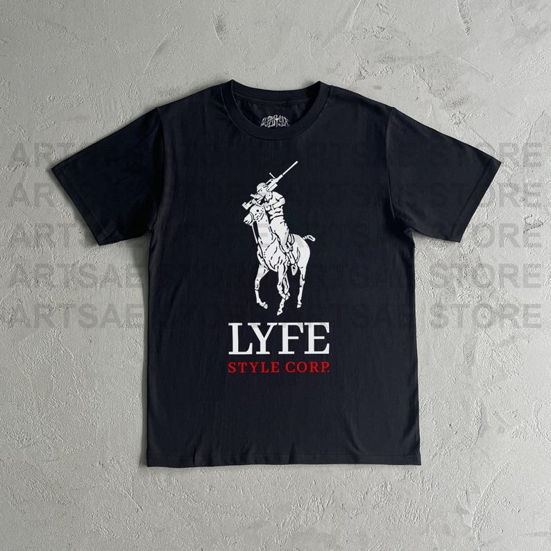 May include: Black t-shirt with a white graphic of a person riding a horse holding a rifle. The text "LYFE STYLE CORP." is printed below the graphic.