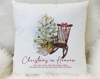 May include: A white square throw pillow featuring a watercolor illustration of a decorated Christmas tree, a dark brown wooden rocking chair with a red bow, and wrapped gifts. The text reads: Christmas in Heaven, Save me a seat, just one empty chair, You may not see me, but know that I'm there.
