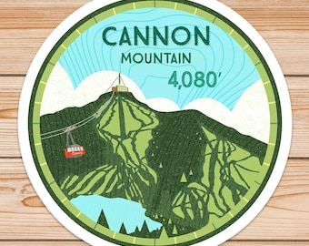 May include: A round sticker featuring a green mountain illustration against a blue sky. The sticker reads "Cannon Mountain 4,080'" in white text.
