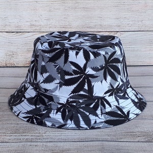 May include: A black and white bucket hat with a marijuana leaf pattern.