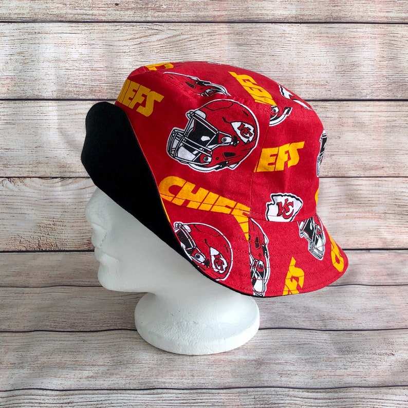 May include: Red and black bucket hat with a Chiefs logo and the word "Chiefs" repeated on the fabric. The hat has a black brim and a red crown.