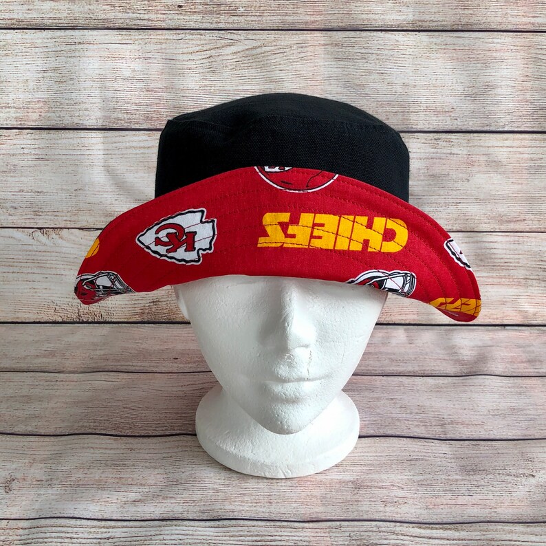 May include: A red and black bucket hat with a Kansas City Chiefs logo and the word "Chiefs" in yellow letters.