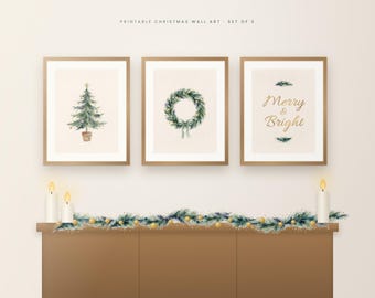 Puede incluir: Un conjunto de tres láminas decorativas enmarcadas con un árbol de Navidad en acuarela, una corona verde y el texto dorado Merry & Bright. Las láminas se muestran sobre una repisa decorada con una guirnalda de pino.