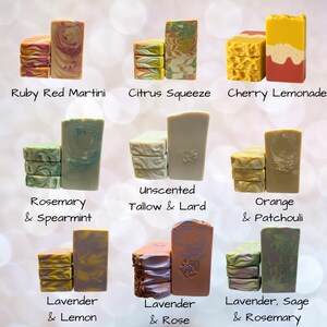 May include: Nine rectangular bars of soap arranged in groups of three, each labeled with names including Ruby Red Martini, Citrus Squeeze, Cherry Lemonade, Rosemary & Spearmint, Unscented Tallow & Lard, Orange & Patchouli, Lavender & Lemon, Lavender & Rose, and Lavender, Sage & Rosemary.