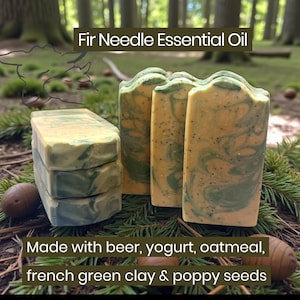 May include: Rectangular bars of soap with a marbled yellow and green pattern, speckled with poppy seeds. The text reads: Fir Needle Essential Oil. Made with beer, yogurt, oatmeal, french green clay & poppy seeds. The soap has a textured top.