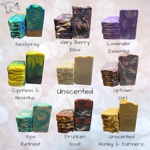 May include: A collection of nine varieties of rectangular soap bars, each labeled with names including SeaSpray, Very Berry Bliss, Lavender Essential, Cypress & Absinthe, Unscented, Uptown Girl, Spa Retreat, Drunken Goat, and Unscented Honey & Turmeric.