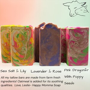 May include: Three rectangular bars of soap with marbled patterns. The left bar features yellow, green, and pink swirls. The center bar is purple and brown. The right bar is pink and green. Text reads: Sea Salt & Lily, Lavender & Rose, Pink Dragonfr With Poppy Seeds.