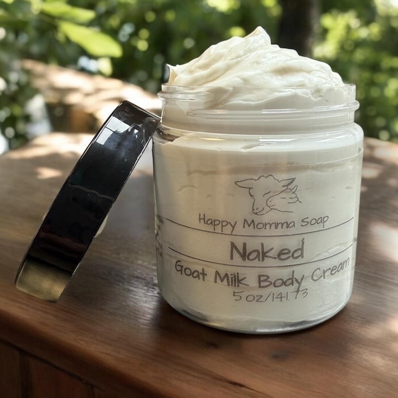 May include: A glass jar with a black lid filled with a white goat milk body cream. The jar has a label that reads "Happy Momma Soap" and "Naked Goat Milk Body Cream 5 oz/141.73".