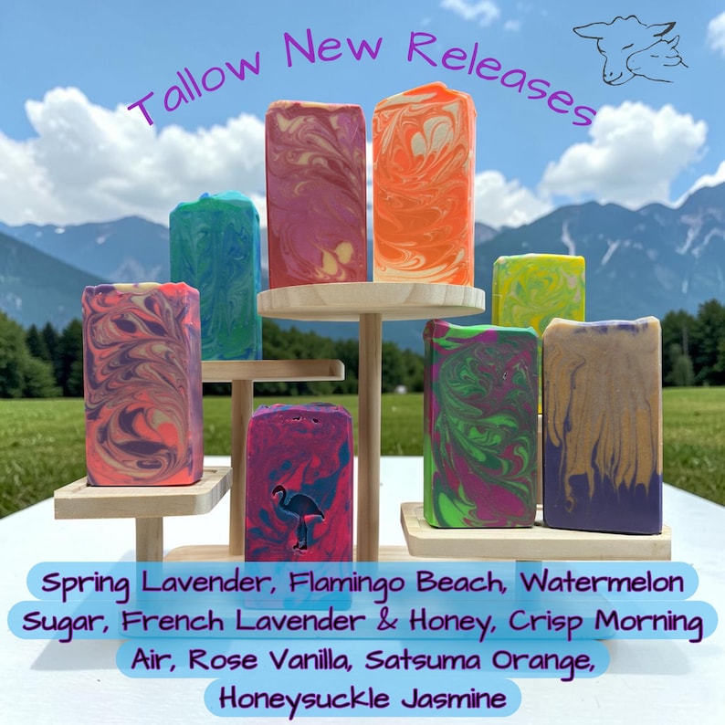 May include: A collection of eight rectangular soap bars with marbled patterns in vibrant colors, displayed on a tiered wooden stand. The text "Tallow New Releases" appears at the top, and a list of scents is printed at the bottom of the image.