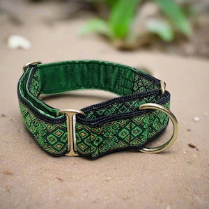 May include: A green and black fabric collar featuring a repeating geometric diamond pattern. The collar includes gold-toned metal hardware, specifically a rectangular slide and a D-ring, and is lined with a solid green fabric on the interior.