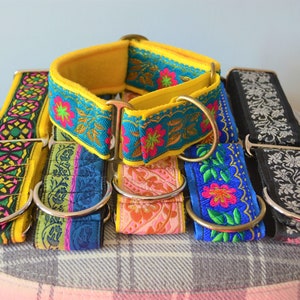 May include: Five colourful dog collars with floral patterns and silver metal hardware. The collars are stacked on top of each other.