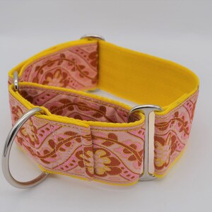 May include: A yellow and pink patterned dog collar with silver hardware. The collar is made of a soft, durable material and is designed to be comfortable for dogs of all sizes.