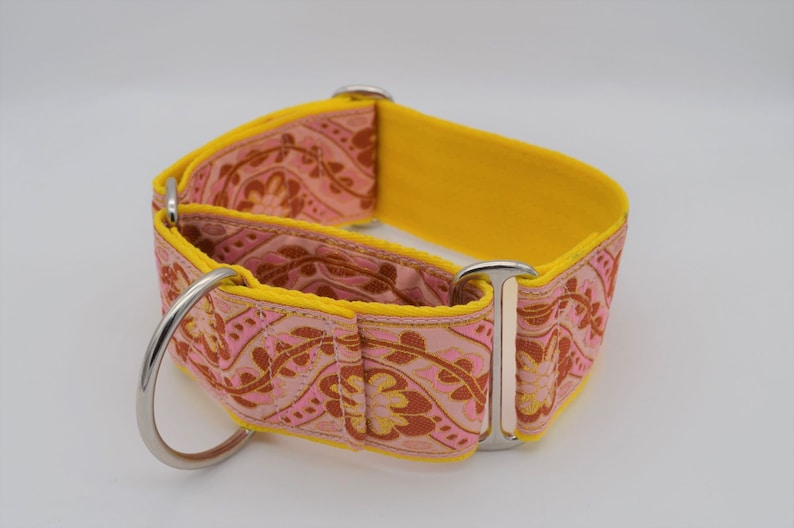 May include: A yellow and pink patterned dog collar with silver hardware. The collar is made of a soft, durable material and is designed to be comfortable for dogs of all sizes.