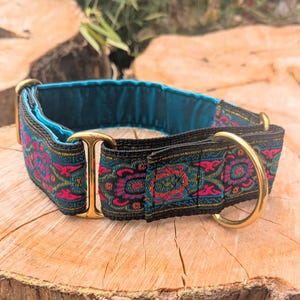 May include: A pet collar featuring a vibrant woven pattern in shades of hot pink, teal, and black. The collar includes polished brass hardware, including a D-ring and a sliding adjuster, and is lined with a smooth, solid teal fabric interior.