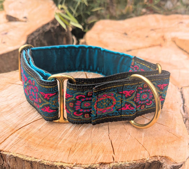 May include: A pet collar featuring a vibrant woven pattern in shades of hot pink, teal, and black. The collar includes polished brass hardware, including a D-ring and a sliding adjuster, and is lined with a smooth, solid teal fabric interior.