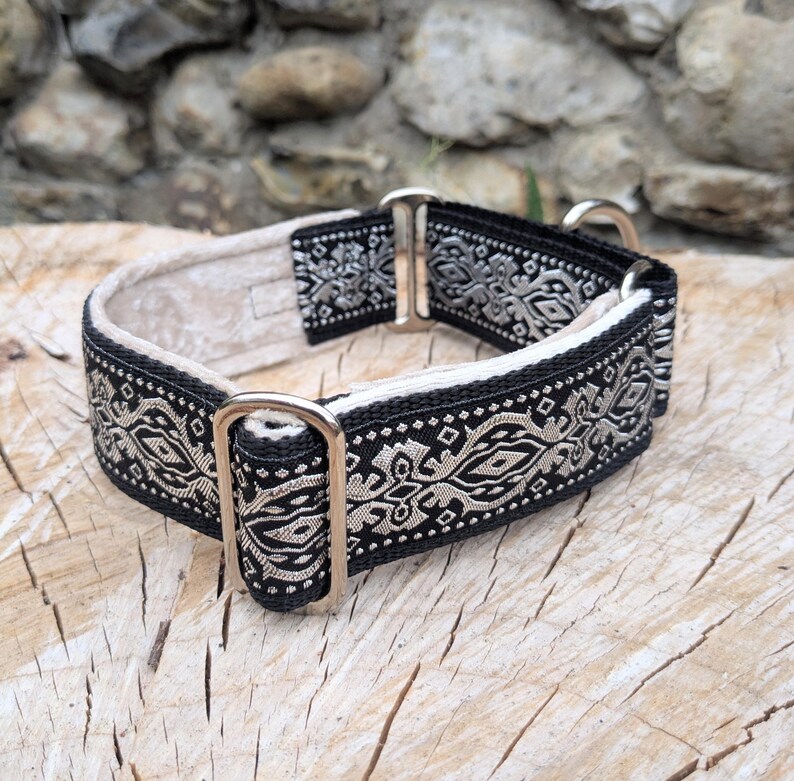 May include: A black and beige patterned collar featuring a repeating geometric design. The collar is constructed with a durable fabric strap, a light-colored interior lining, and polished silver-toned metal hardware including a rectangular slide.