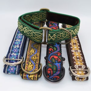 May include: Five dog collars with different patterns and colours. The collars are made of fabric with embroidered designs. The collars have silver metal D-rings.