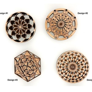 May include: Four wooden decorative designs are displayed against a white background. Design #1 is a dark brown circular floral pattern. Design #2 is a light brown circular design. Design #3 is a geometric hexagon. Design #4 is a circular design with a brown and gray pattern.