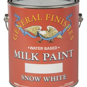 May include: A red can of General Finishes Milk Paint in the color Snow White. The can is labeled with the company logo, a bald eagle with a blue ribbon, and the text "Water Based".