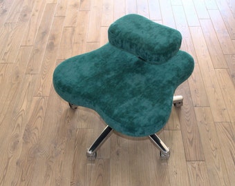 May include: A teal green ergonomic office chair with a contoured seat and a smaller cushion on top. The chair has a chrome base with five wheels.